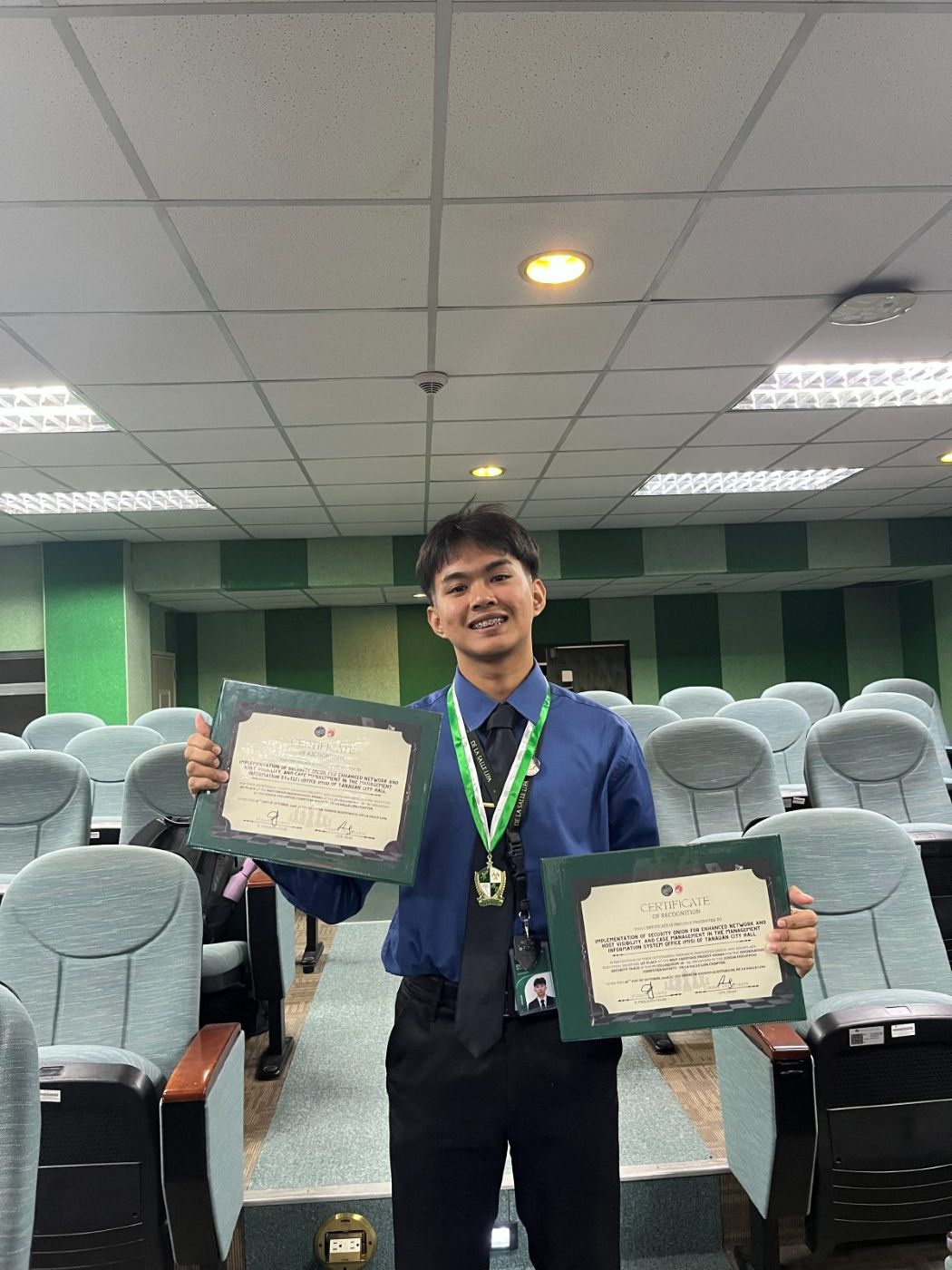 Moises holding both certificates of recognition