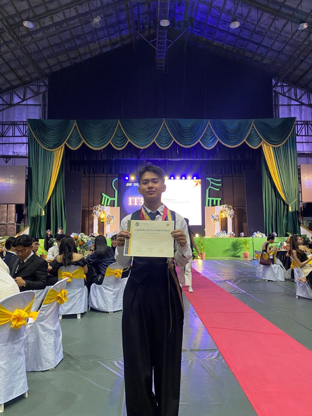 Moises holding the Top Student certificate at the awards night